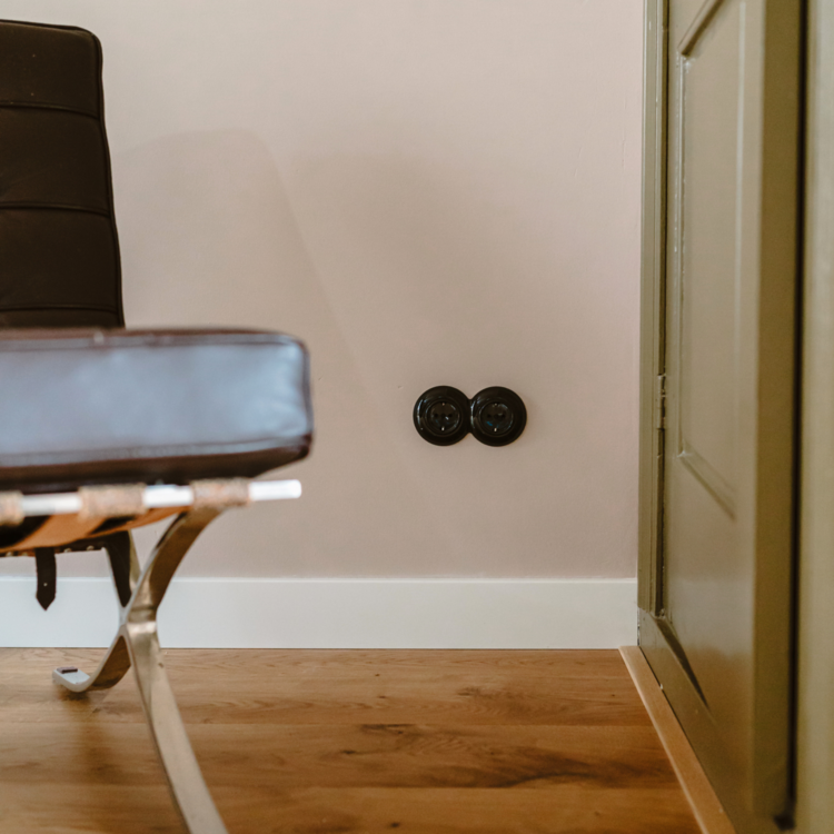 Zwart stopcontact rond 2-voudig afdekraam renovatie de oude schakelaar